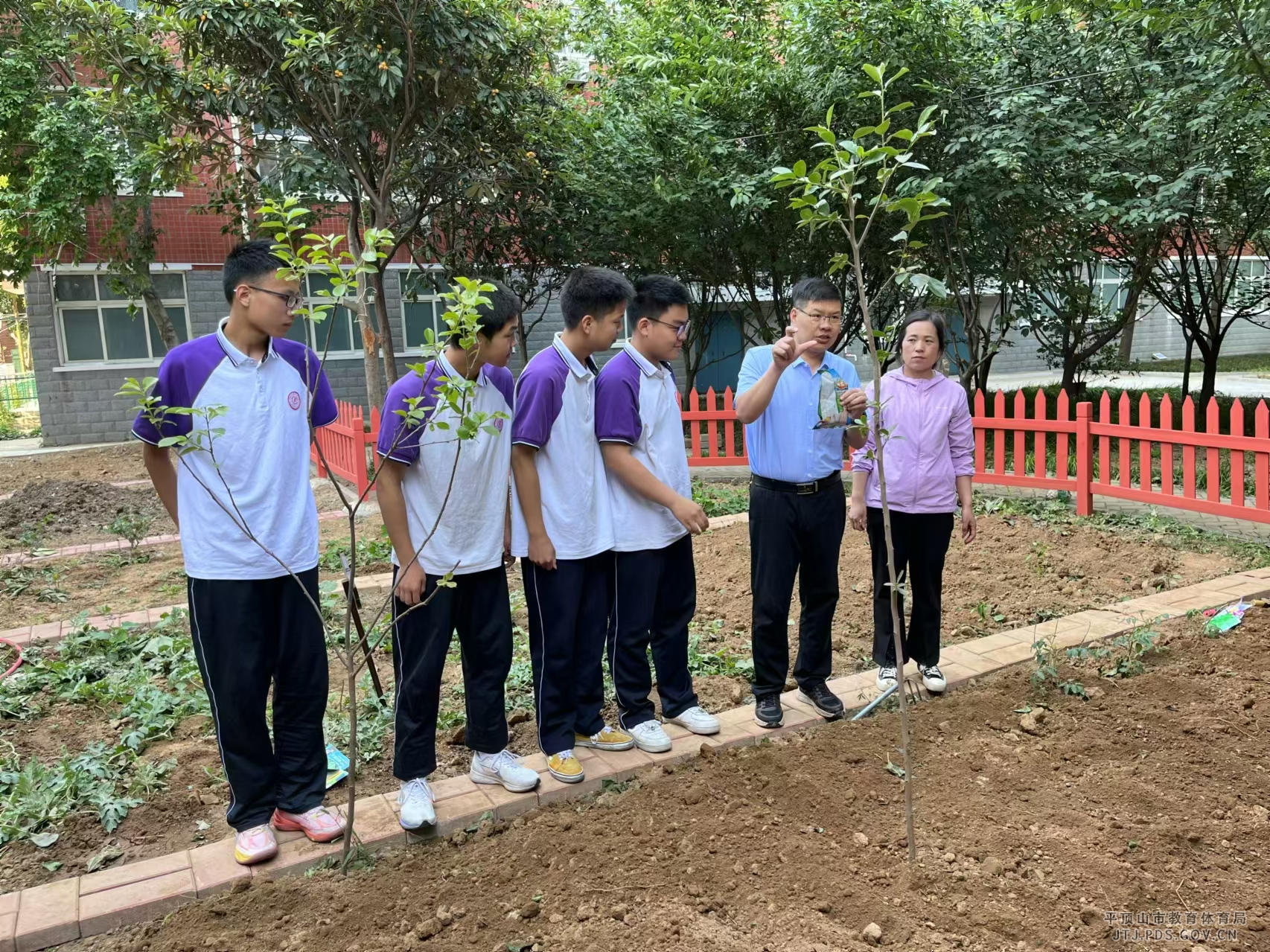 1校长王照阳给学生讲解农作物习性.jpg 1校长王照阳给学生讲解农作物习性.jpg